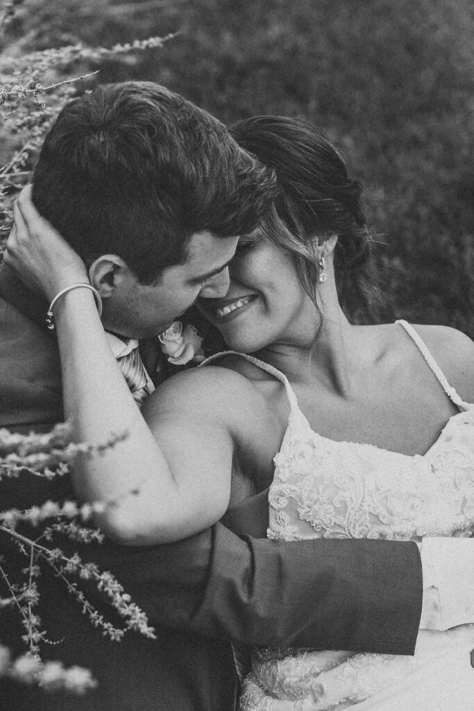 Christine and Michael smiling lovingly at each other in a lush Pennsylvania backyard, celebrating their wedding day