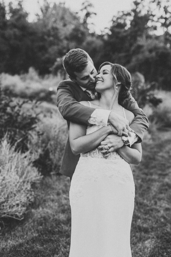 Newlyweds sharing a tender moment amidst the natural beauty of their backyard wedding in Pennsylvania