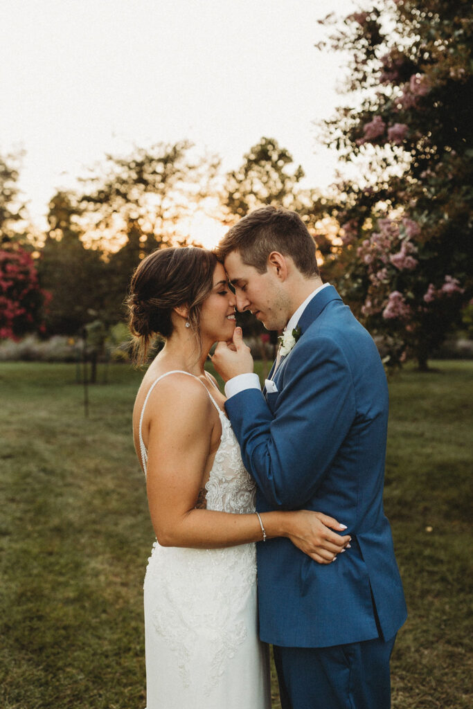 Christine and Michael smiling lovingly at each other in a lush Pennsylvania backyard, celebrating their wedding day