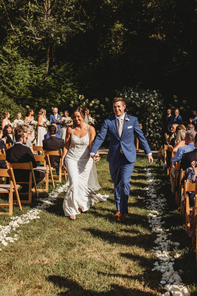 Elegant backyard wedding ceremony in Pennsylvania, with Christine and Michael exchanging vows under a floral arch