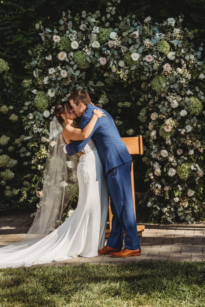 Elegant backyard wedding ceremony in Pennsylvania, with Christine and Michael exchanging vows under a floral arch