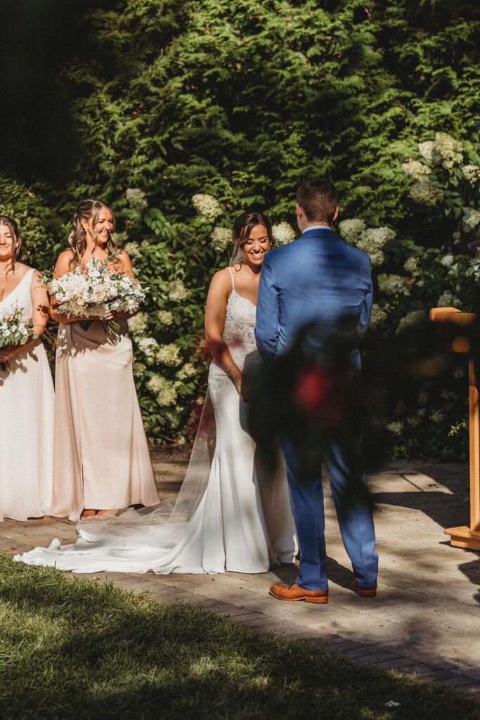 Elegant backyard wedding ceremony in Pennsylvania, with Christine and Michael exchanging vows under a floral arch