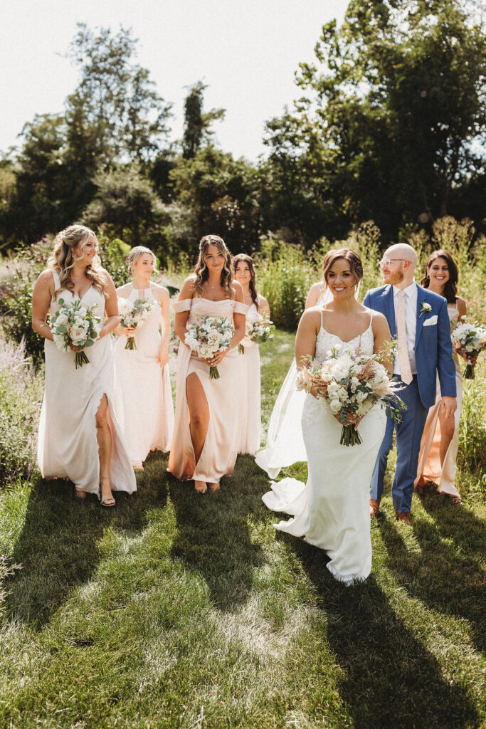 Christine and her wedding party in elegant dresses, sharing laughter in the serene ambiance of a Pennsylvania backyard wedding