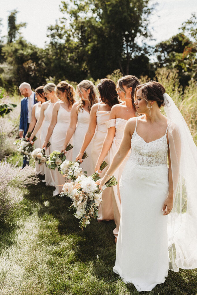 Christine and her wedding party in elegant dresses, sharing laughter in the serene ambiance of a Pennsylvania backyard wedding