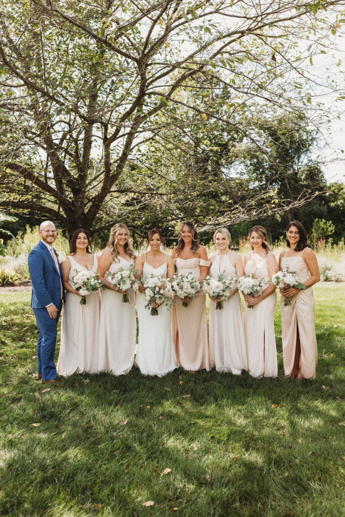 Christine and her wedding party in elegant dresses, sharing laughter in the serene ambiance of a Pennsylvania backyard wedding