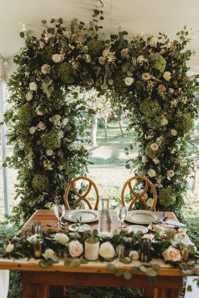 Elegant backyard wedding ceremony in Pennsylvania, with Christine and Michael exchanging vows under a floral arch