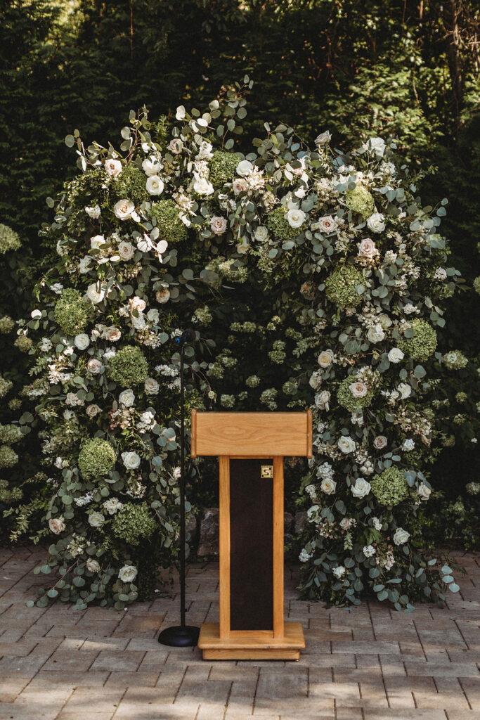 Elegant backyard wedding ceremony in Pennsylvania, with Christine and Michael exchanging vows under a floral arch