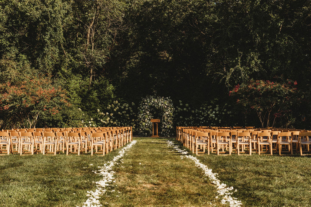 Elegant backyard wedding ceremony in Pennsylvania, with Christine and Michael exchanging vows under a floral arch