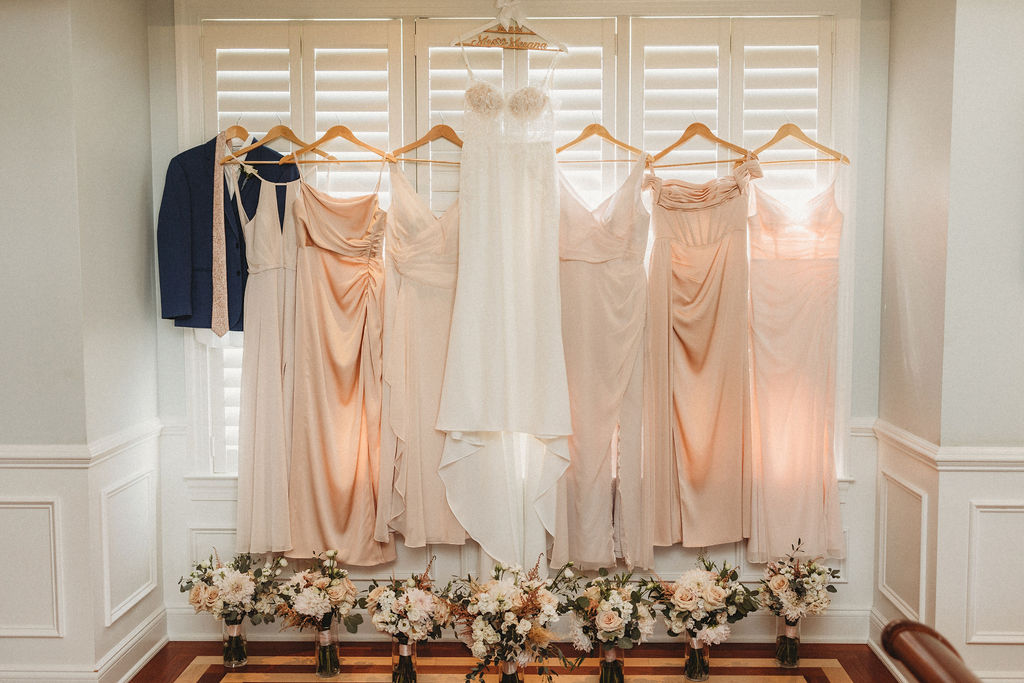 Bride and bridesmaid dresses hanging on the window