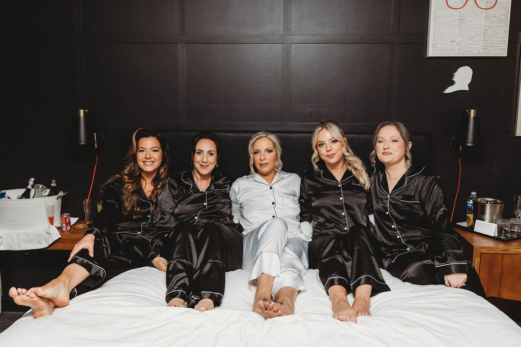 bride and bridesmaids in bed wearing silk pjs