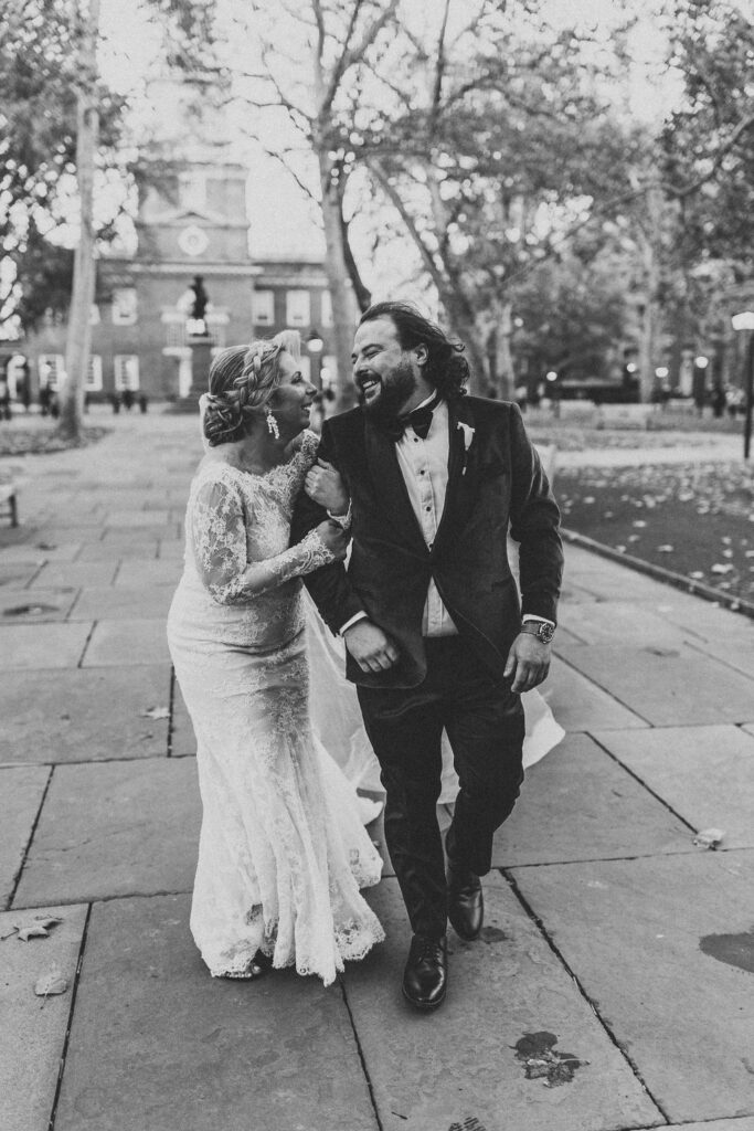 candid bride and groom walking around and snapping pics in downtown philadelphia