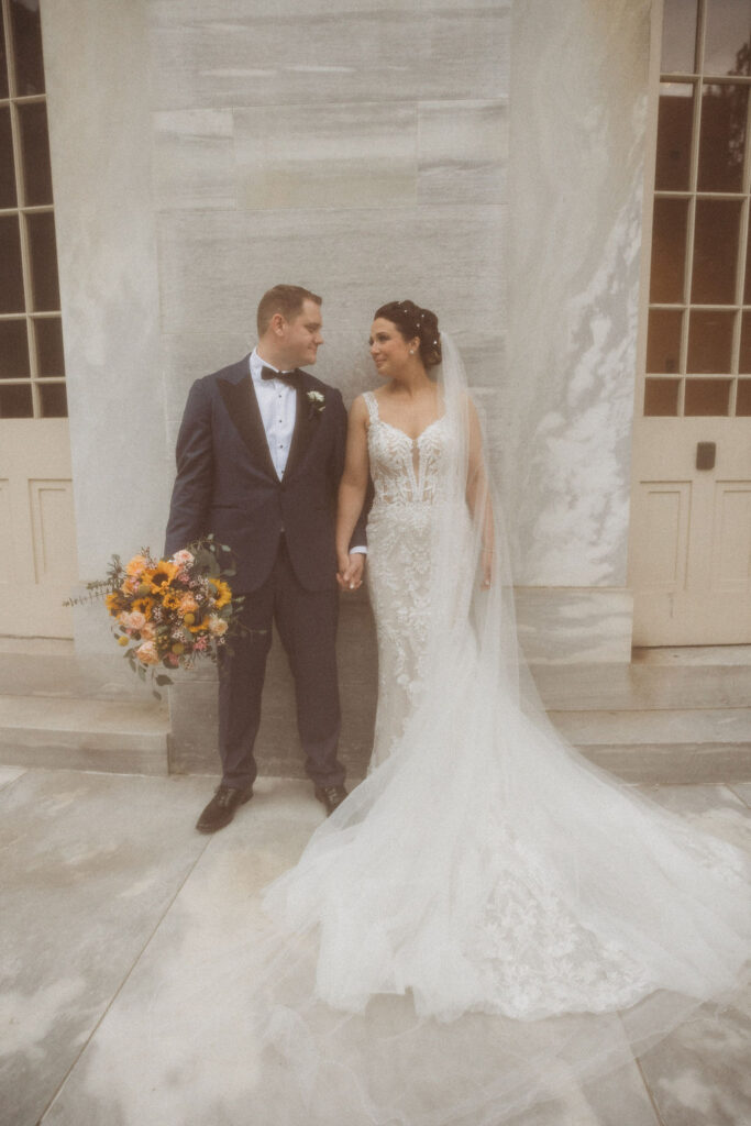 bride and groom posing at the Merchants exchange building in philadelphia