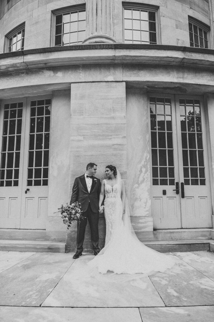 bride and groom posing at the Merchants exchange building in philadelphia