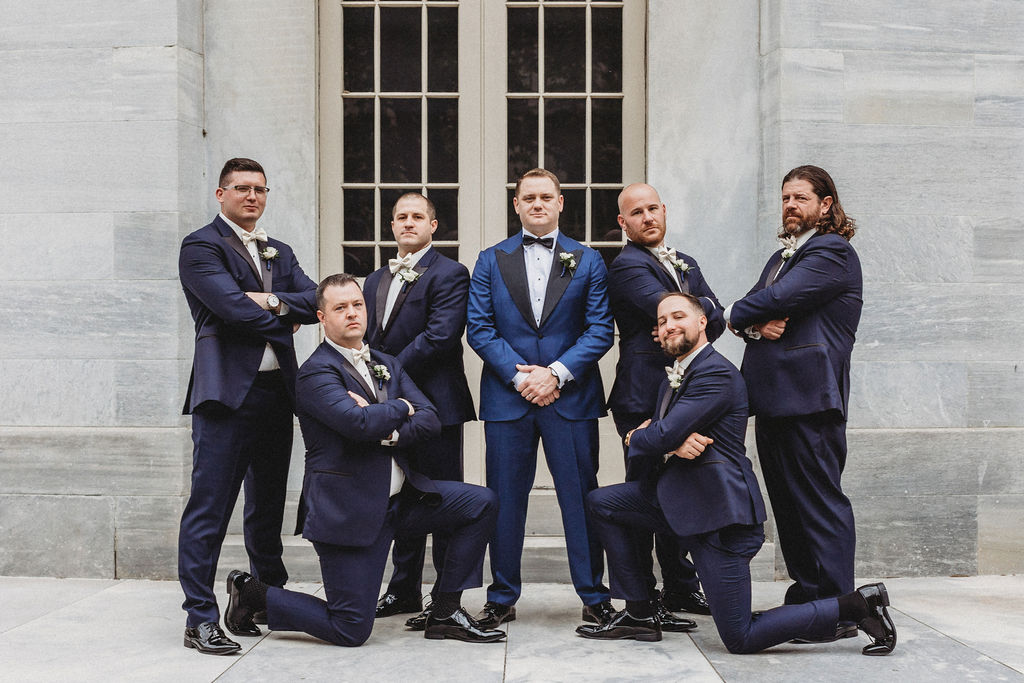 funny groom and groomsmen posing at the merchants exchange building