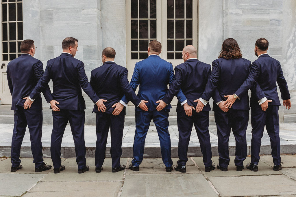 funny groom and groomsmen posing at the merchants exchange building