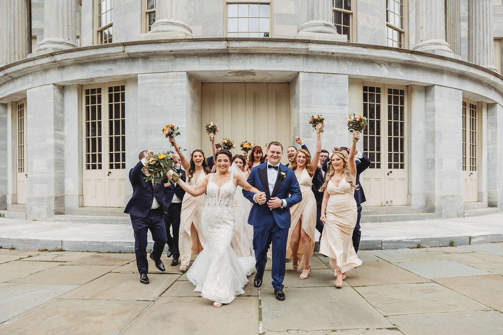 the wedding couple posing with their wedding party at the merchants exchange building in philadelphia