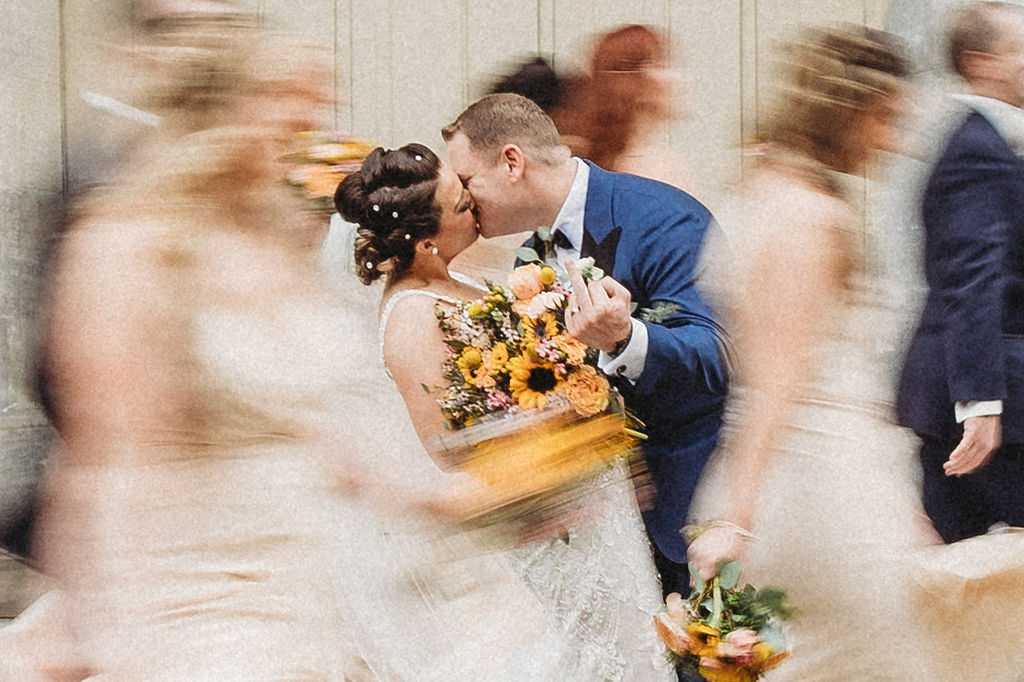 the wedding couple posing with their wedding party at the merchants exchange building in philadelphia