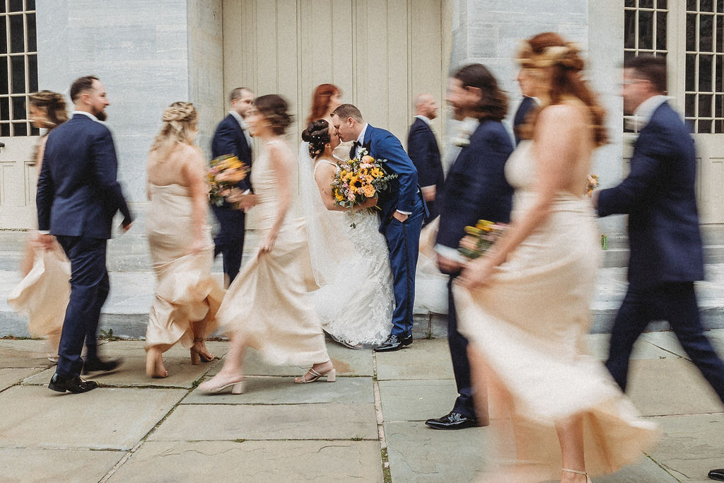 the wedding couple posing with their wedding party at the merchants exchange building in philadelphia