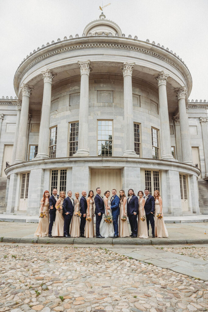 the wedding couple posing with their wedding party at the merchants exchange building in philadelphia