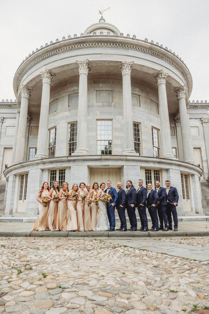 the wedding couple posing with their wedding party at the merchants exchange building in philadelphia