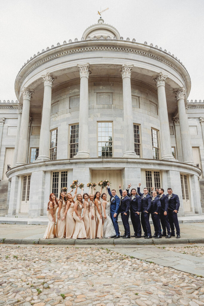 the wedding couple posing with their wedding party at the merchants exchange building in philadelphia