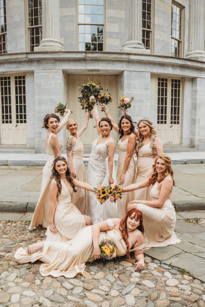 bride and bridesmaids in neutral bridesmaid dresses at the merchants exchange building in philadelphia