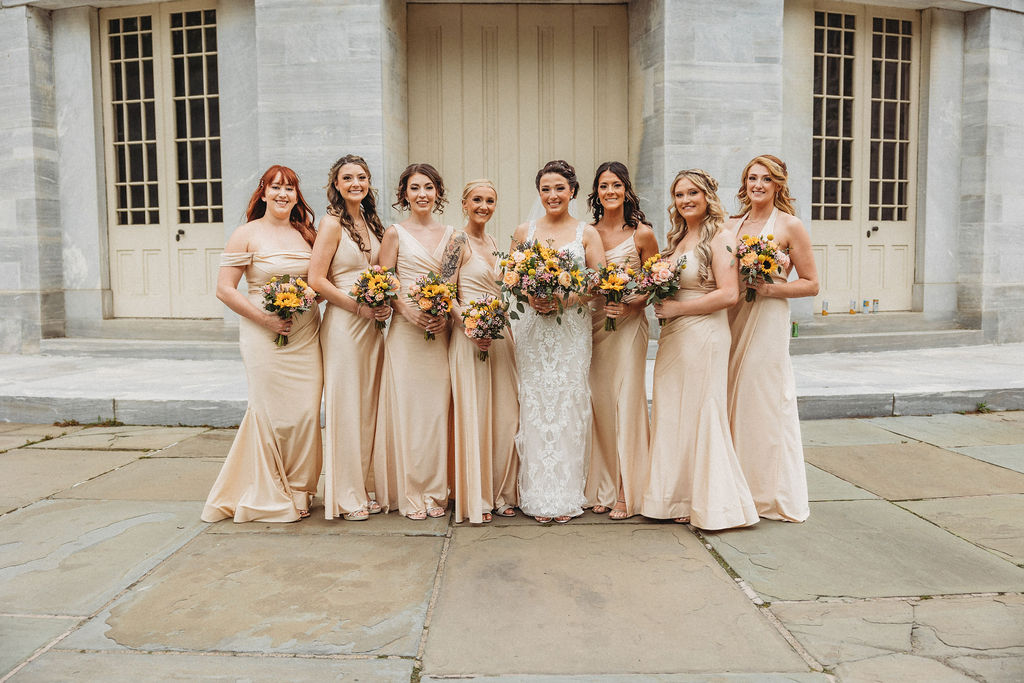 bride and bridesmaids in neutral bridesmaid dresses at the merchants exchange building in philadelphia