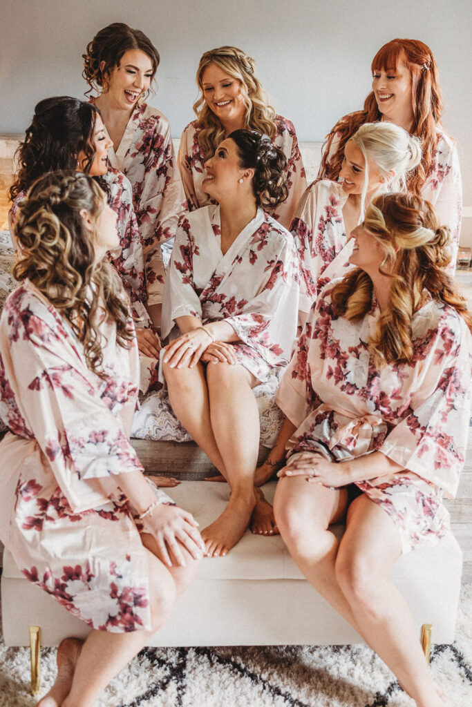 bride and bridesmaids sitting on the bed in matching robes