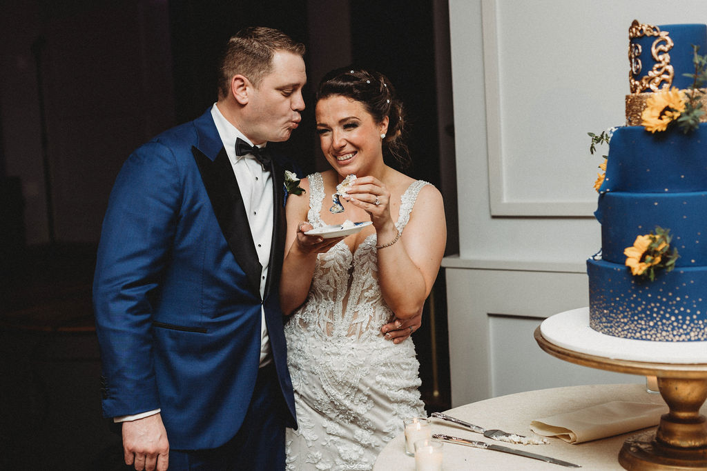 bride and groom cutting their four tiered blue wedding cake