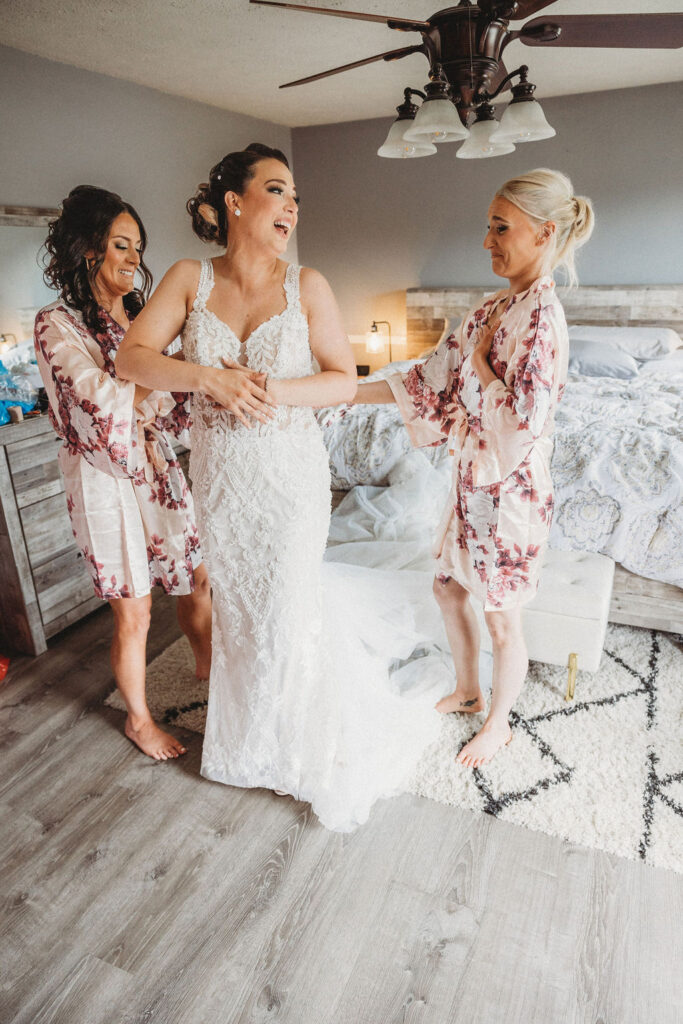 bridesmaids helping the bride get ready in a hotel room