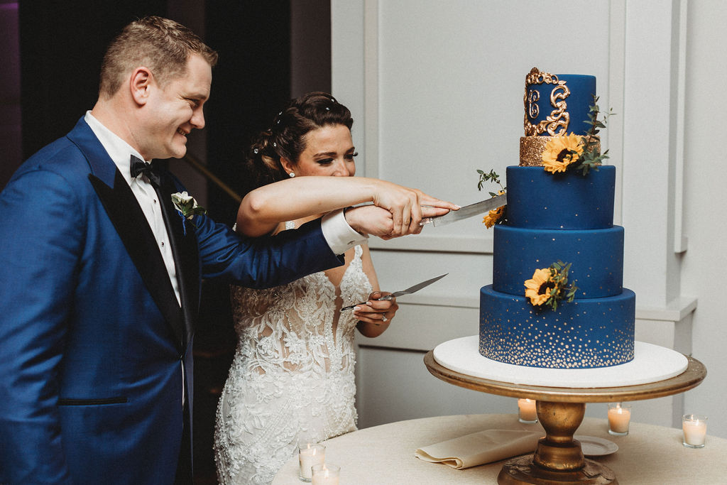 bride and groom cutting their four tiered blue wedding cake